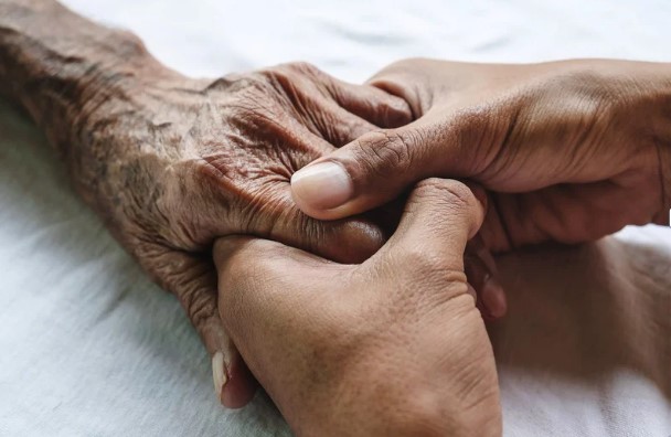 Caregiver holding patients hand